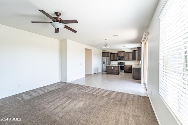 unfurnished living room with ceiling fan with notable chandelier and sink