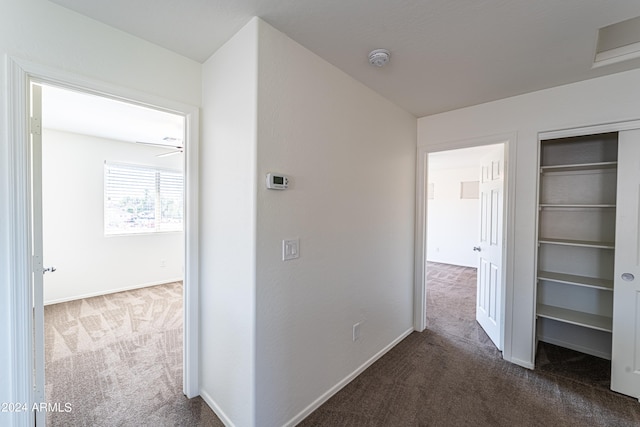 hallway with dark colored carpet