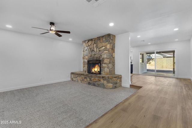 unfurnished living room featuring ceiling fan, wood-type flooring, and a fireplace