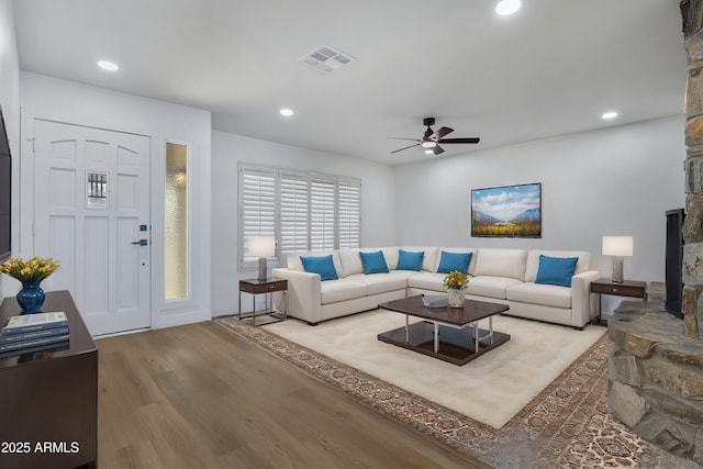 living room with ceiling fan and light hardwood / wood-style flooring