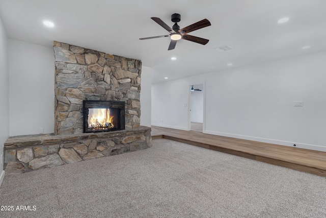 unfurnished living room with ceiling fan, a fireplace, and carpet floors