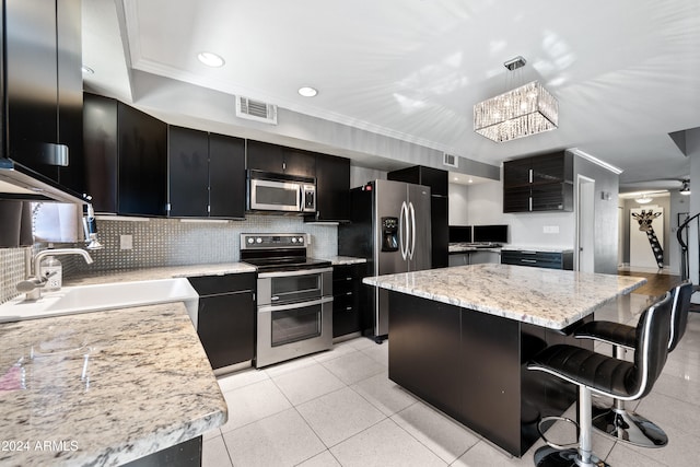 kitchen with a kitchen island, decorative backsplash, stainless steel appliances, sink, and ornamental molding