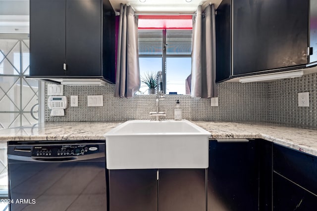 kitchen featuring light stone countertops, black dishwasher, sink, and backsplash