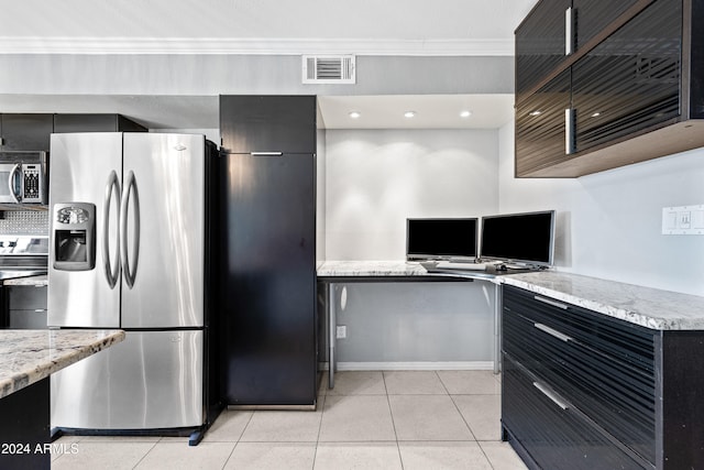 kitchen with light stone counters, light tile patterned flooring, appliances with stainless steel finishes, and ornamental molding