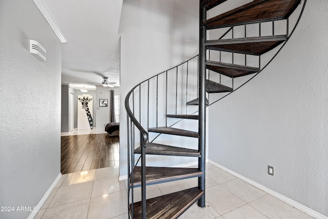 staircase with ornamental molding, hardwood / wood-style floors, and ceiling fan