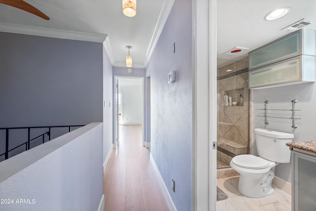 bathroom with a shower with door, hardwood / wood-style floors, vanity, and toilet