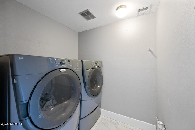 laundry room featuring washing machine and dryer and a textured ceiling