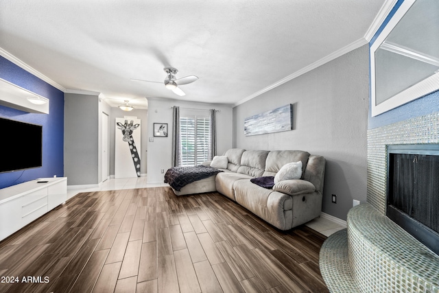 living room featuring ceiling fan, a textured ceiling, crown molding, and hardwood / wood-style floors