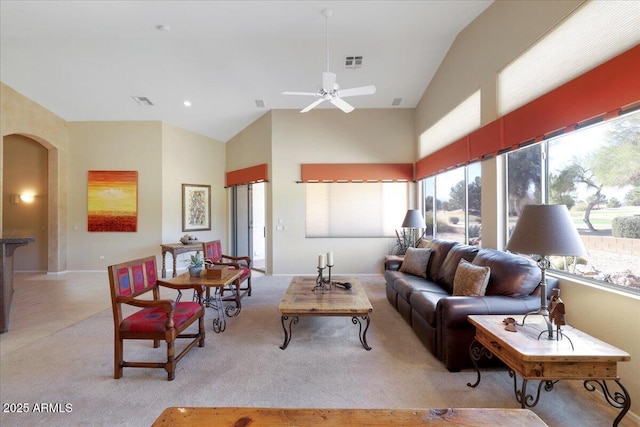 carpeted living room with a high ceiling and ceiling fan