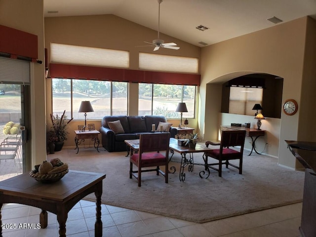 carpeted living room with ceiling fan, high vaulted ceiling, and a healthy amount of sunlight