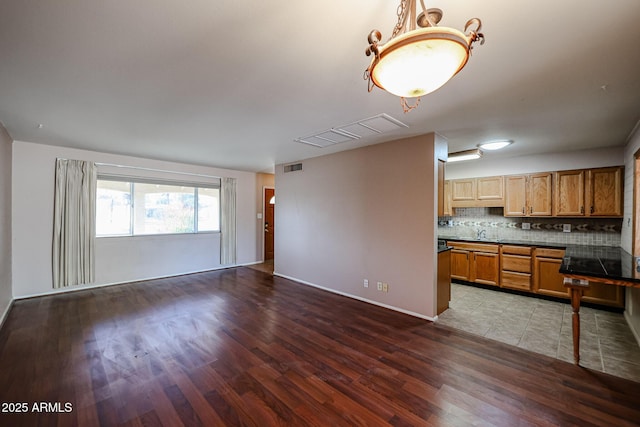 kitchen featuring tasteful backsplash, hardwood / wood-style flooring, and sink