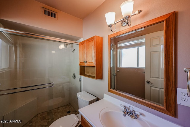 bathroom with walk in shower, vanity, and toilet