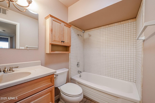 full bathroom with tiled shower / bath, vanity, and toilet