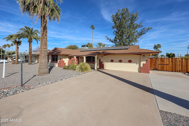 ranch-style house with a garage and solar panels