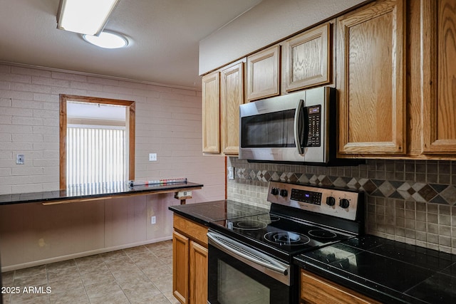 kitchen featuring crown molding, appliances with stainless steel finishes, and decorative backsplash