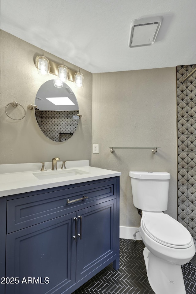 bathroom with toilet, vanity, and tile patterned flooring