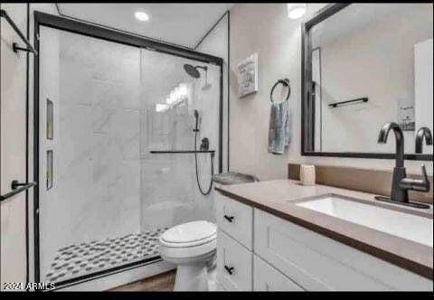 bathroom featuring vanity, a baseboard radiator, toilet, and an enclosed shower