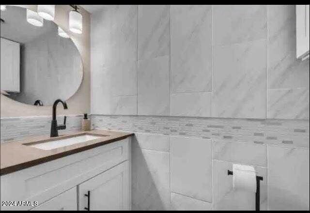 bathroom featuring vanity and tile walls