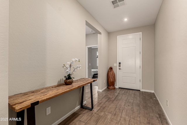 doorway to outside with visible vents, baseboards, and wood finished floors