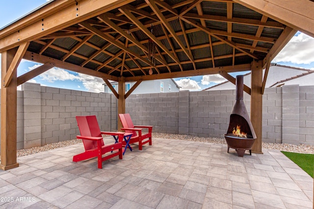 view of patio / terrace featuring a fenced backyard, a fire pit, and a gazebo