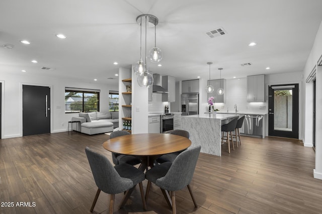 dining room featuring dark hardwood / wood-style flooring, sink, and plenty of natural light