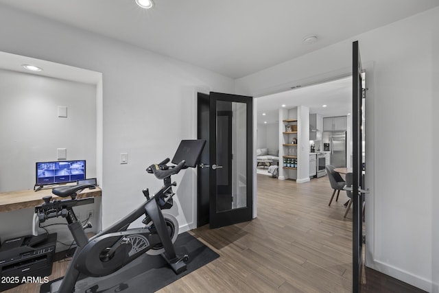 exercise area with hardwood / wood-style floors and french doors