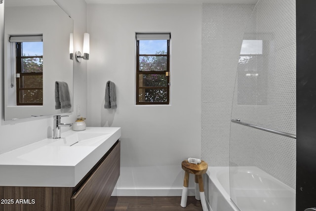 bathroom with hardwood / wood-style flooring, vanity, and tub / shower combination