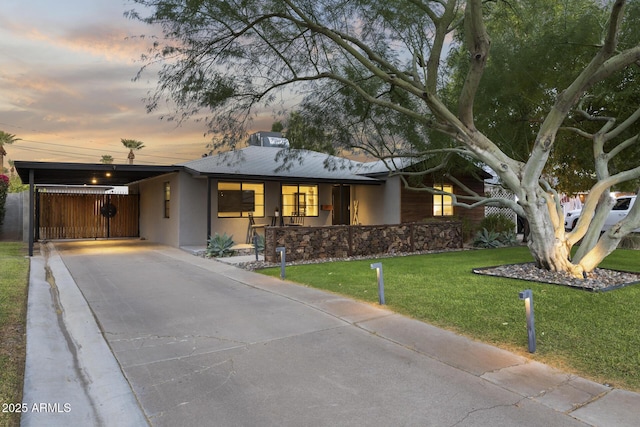 view of front of property with a yard and a carport