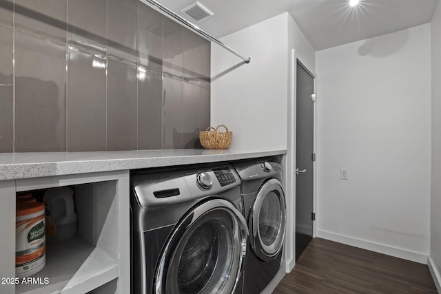 laundry area featuring separate washer and dryer and dark hardwood / wood-style flooring