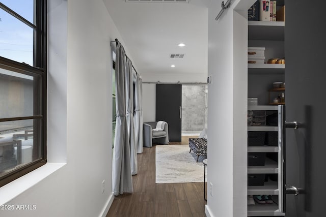 corridor featuring dark hardwood / wood-style floors and a barn door