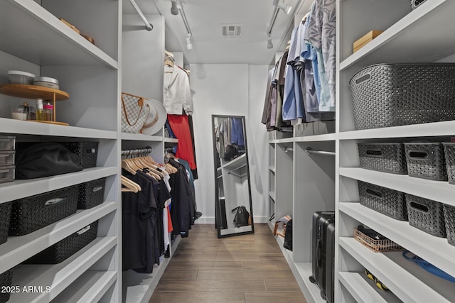 walk in closet with hardwood / wood-style floors