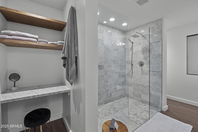 bathroom featuring hardwood / wood-style floors and a tile shower