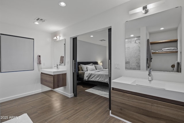 bathroom featuring wood-type flooring, vanity, and a shower