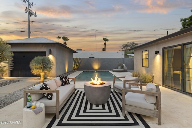 patio terrace at dusk with an outdoor living space with a fire pit