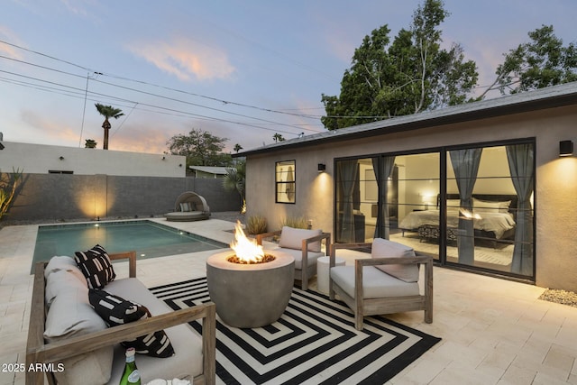 pool at dusk with a patio and a fire pit