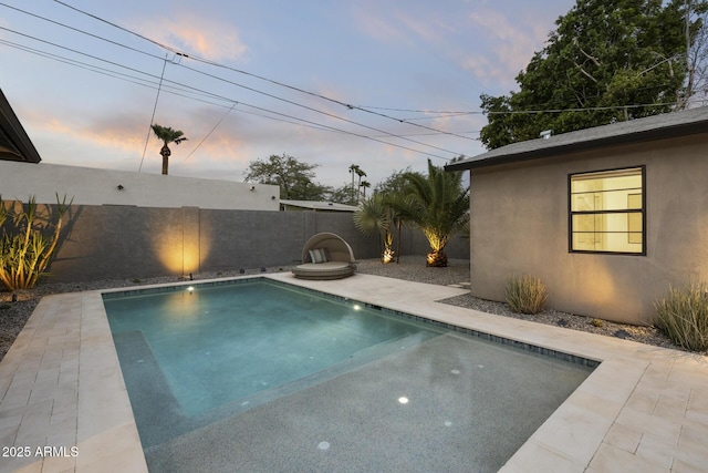 pool at dusk with a patio area