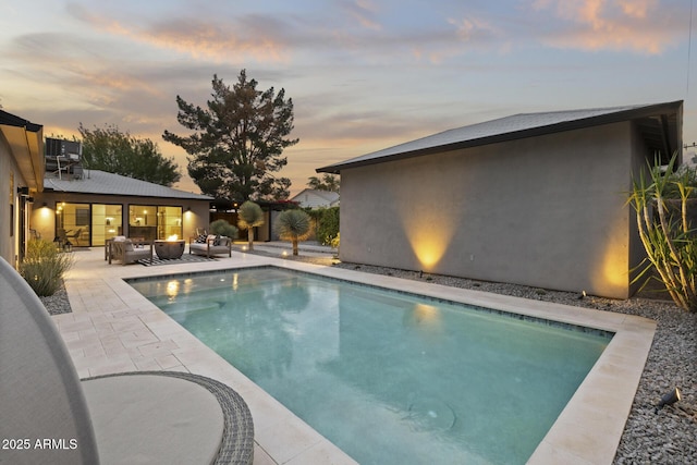 pool at dusk featuring a patio area