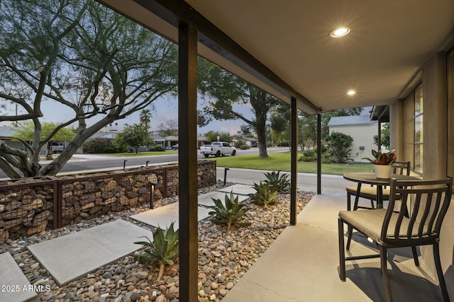 patio terrace at dusk featuring a porch