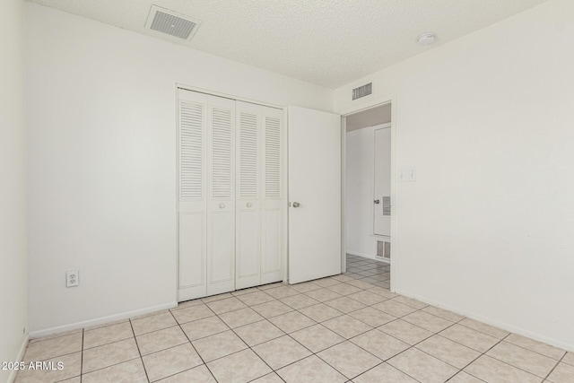 1512 W Crescent Ave, Mesa, AZ 85202 - unfurnished bedroom featuring a closet, a textured ceiling, baseboards, and light tile patterned floors
