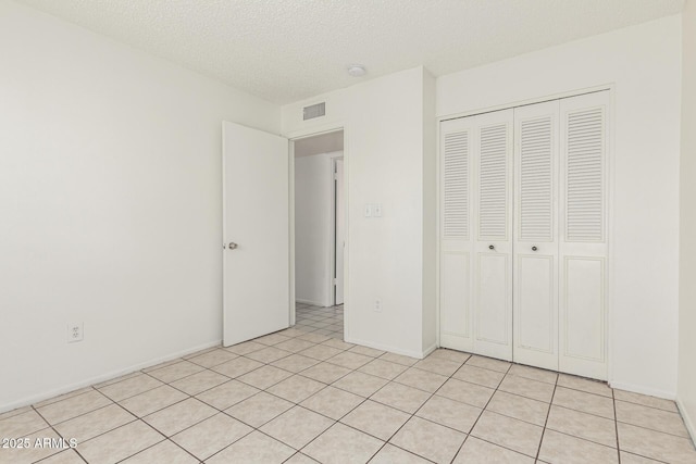 1512 W Crescent Ave, Mesa, AZ 85202 - unfurnished bedroom with a closet, a textured ceiling, light tile patterned floors, and baseboards