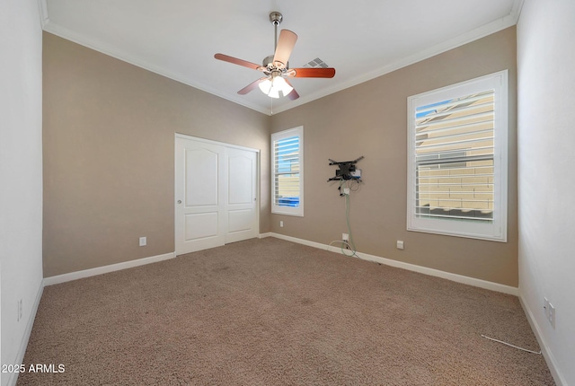 empty room featuring ornamental molding, carpet flooring, and ceiling fan