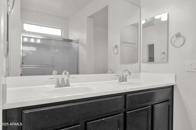 bathroom with vanity and a shower with door