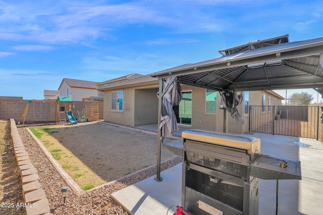 rear view of house featuring a patio and a playground