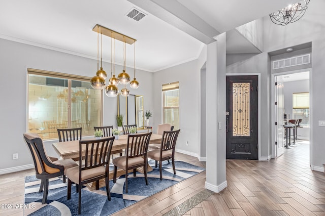 dining room with plenty of natural light, light hardwood / wood-style floors, ornamental molding, and a notable chandelier