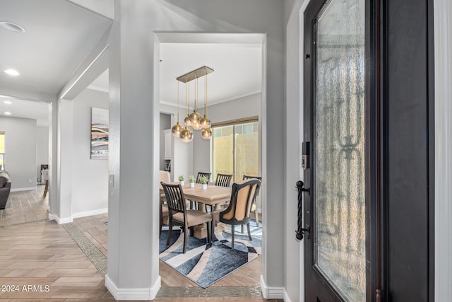 dining room featuring an inviting chandelier, ornamental molding, and light hardwood / wood-style floors