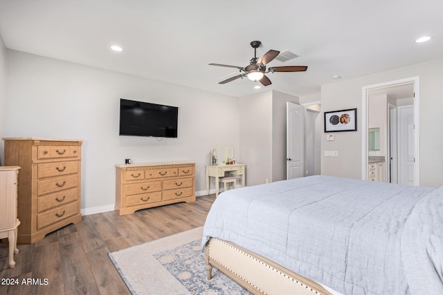 bedroom with ceiling fan, ensuite bathroom, and wood-type flooring