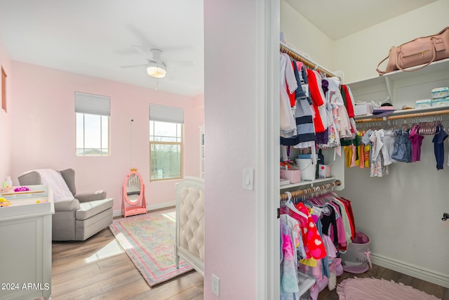 spacious closet featuring light hardwood / wood-style floors and ceiling fan