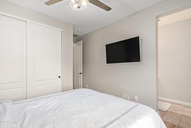 tiled bedroom with ceiling fan and a closet