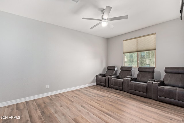 home theater room with ceiling fan and light hardwood / wood-style flooring