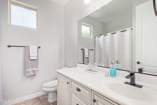 bathroom with tile flooring, toilet, and vanity